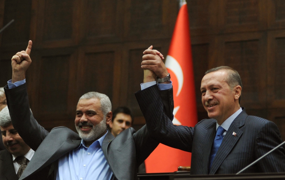 Ismail Haniyeh (left) and his Turkish counterpart Recep Tayyip Erdogan salute together the lawmakers of Erdogan's Islamic-rooted Justice and Development Party at the Parliament in Ankara on  January 3, 2012. — AFP pic