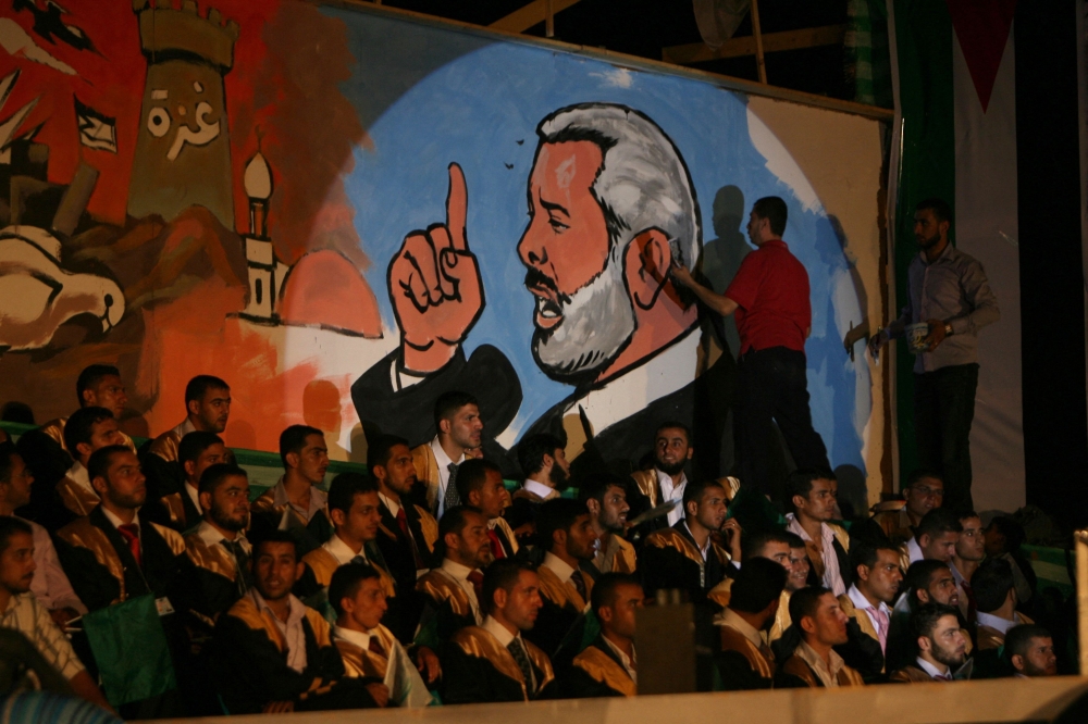 Palestinians decorate a wall with a picture of Ismail Haniyeh during a mass wedding ceremony for 240 couples in Rafah in Gaza Strip, on August 5, 2010. — AFP pic