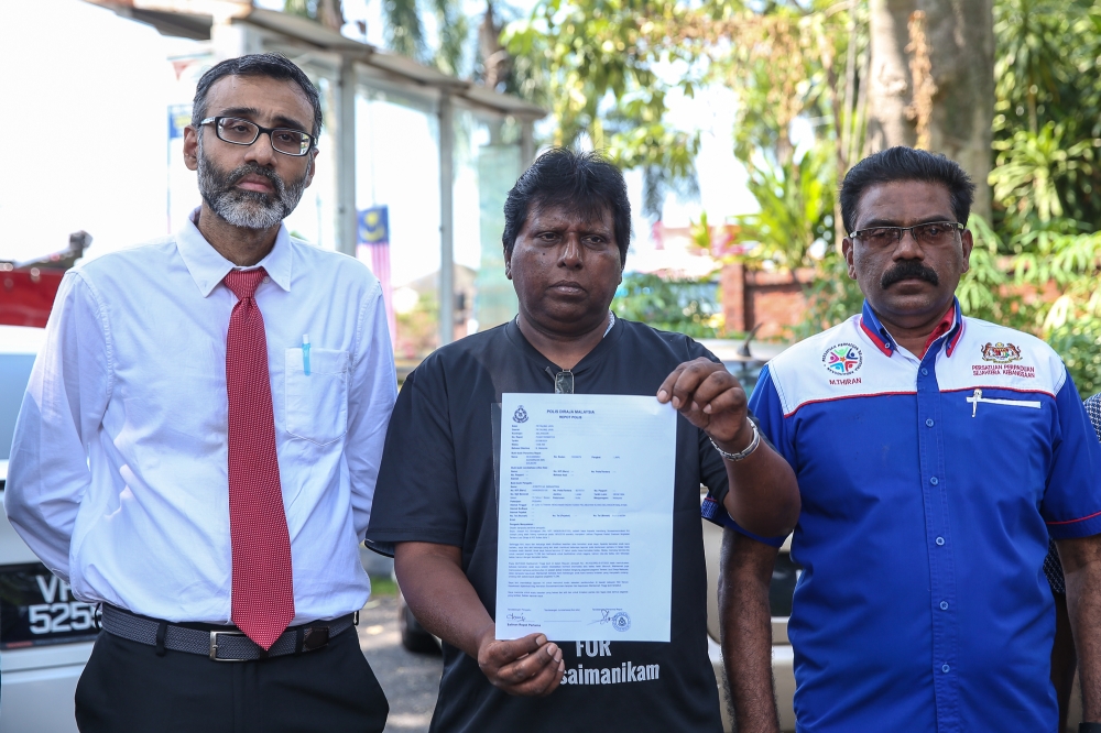 Joseph Sinnappan (centre) show a police report outside the IPD Petaling Jaya August 1, 2024. — Picture by Yusof Mat Isa