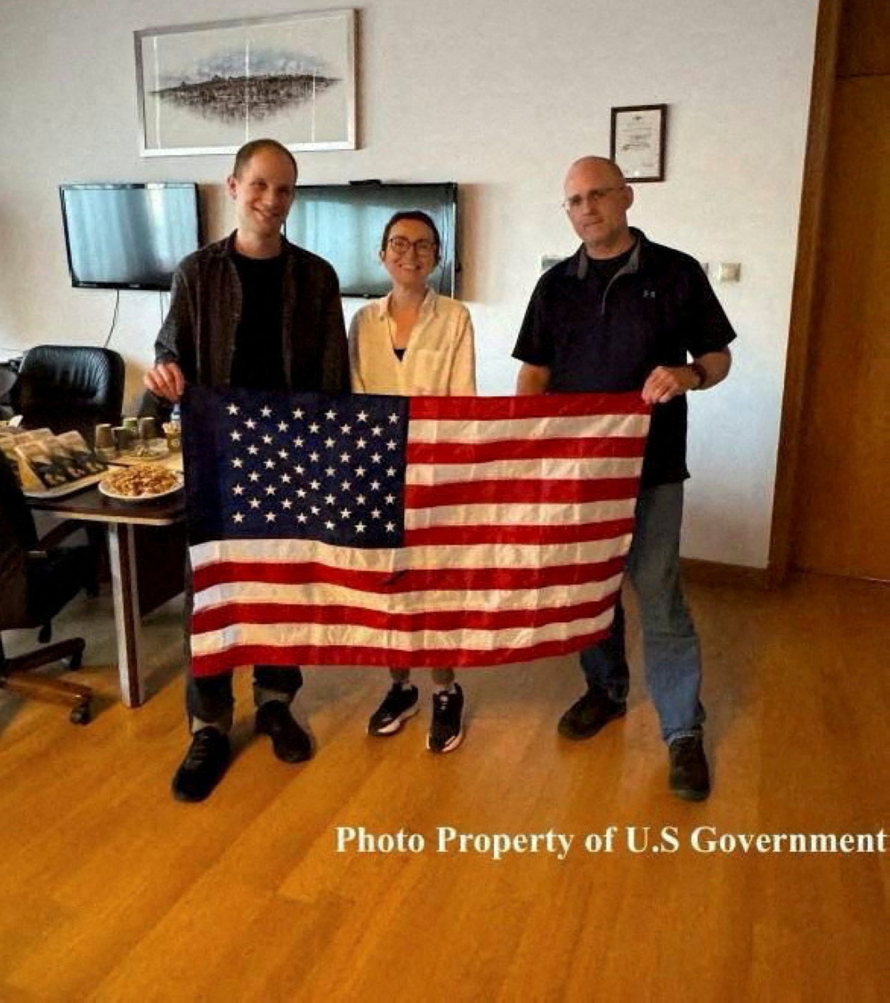 Evan Gershkovich, Alsu Kurmasheva, and Paul Whelan, who were detained in Russia, pose with a US flag as they celebrate their freedom in this undated handout photograph obtained on August 1, 2024. — Reuters pic