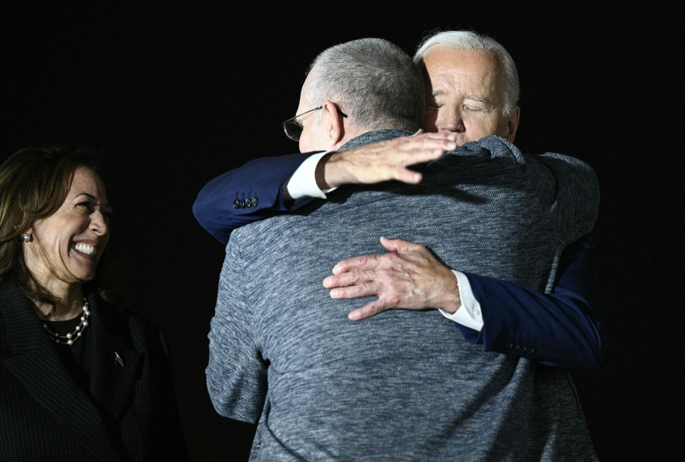 US Vice President Kamala Harris smiles as US President Joe Biden hugs former US Marine Paul Whelan as he arrives at Joint Base Andrews in Maryland on August 1, 2024. — AFP pic