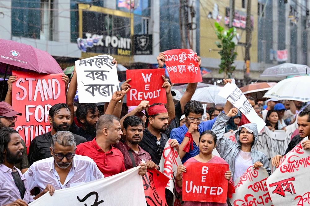 Bangladeshi protesters hold posters during a rally in Dhaka to demand justice for victims arrested and killed in earlier clashes last month with the police over a student-led campaign against civil service job quotas. — AFP pic