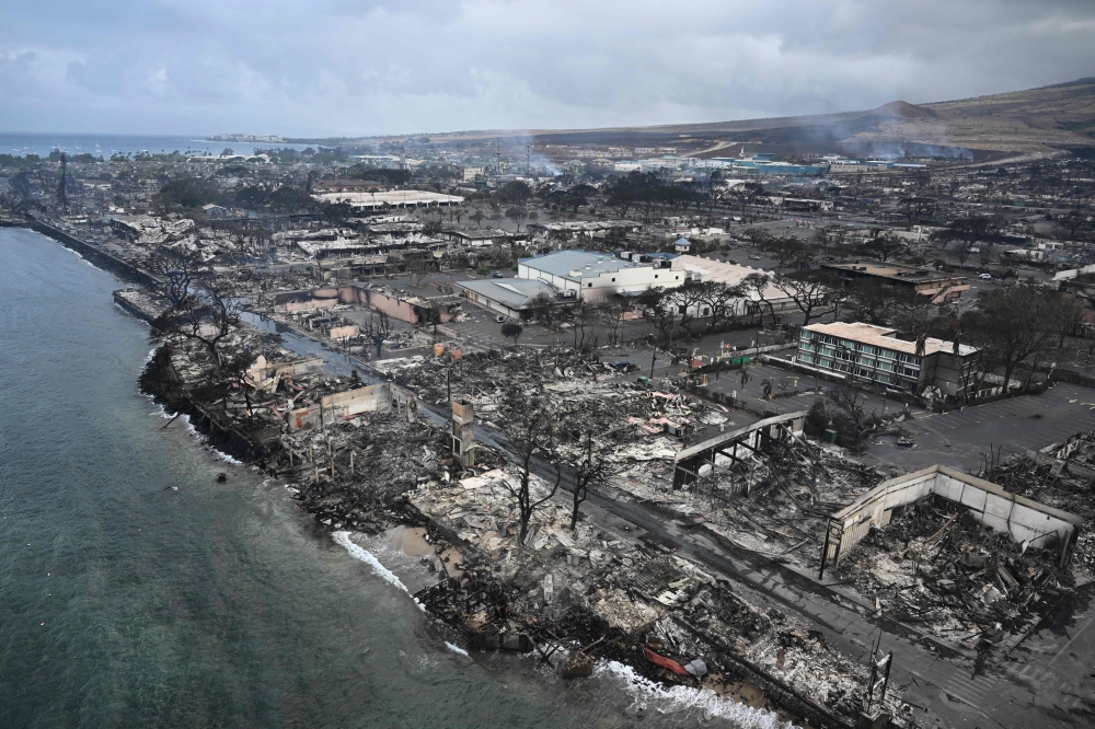 An aerial image shows Old Lahaina Centre and Foodland Lahaina standing amongst destroyed homes and businesses along Front Street burned to the ground in the historic Lahaina in the aftermath of wildfires in western Maui in Lahaina, Hawaii on August 10, 2023. — AFP pic