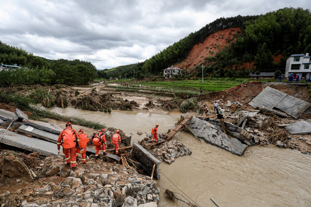Members of a rescue team walk to a flood-affacted area in Zixing, in central China's Hunan province July 29, 2024. Floods and mudslides destroyed village homes and part of a highway in China’s south-western province of Sichuan today, killing at least two people and leaving 17 missing in two incidents. — AFP pic