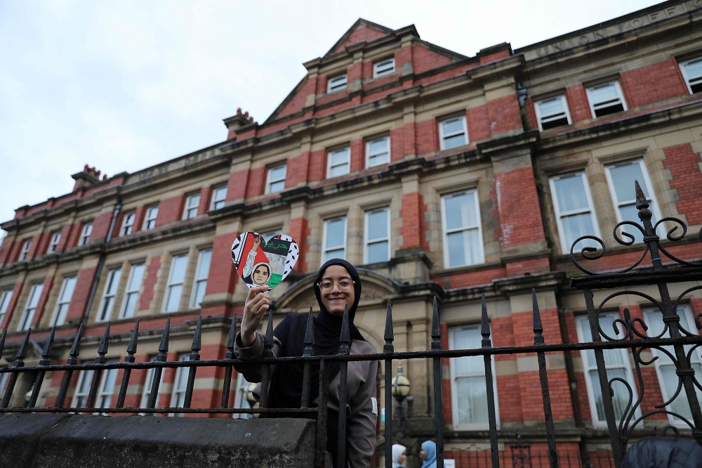 A protester defending the Abdullah Quilliam Mosque in Liverpool holds a heart-shaped placard in the colours of the Palestinian flag reading ‘Freedom’ on August 2, 2024 against the ‘Enough is Enough’ demonstration (not seen) called in reaction to the fatal stabbings in Southport on July 29. — AFP pic
