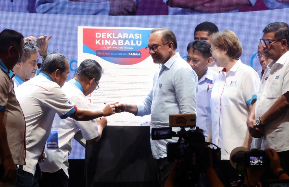 Anwar greets delegates to the PKR Convention at the Sabah International Convention Centre in Kota Kinabalu on August 4, 2024. — Bernama pic