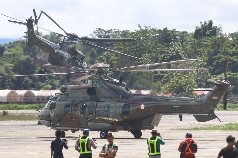 Indonesian Air Force helicopters take off as they evacuate the body of a New Zealand helicopter pilot at Mozes Kilangin Airport in Timika in Indonesia's Central Papua Province on August 6, 2024. — AFP pic