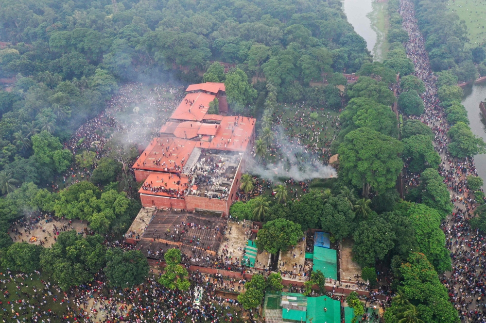 An aerial view shows anti-government protestors storming Bangladesh’s ousted Prime Minister Sheikh Hasina’s palace in Dhaka on August 5, 2024. — AFP pic