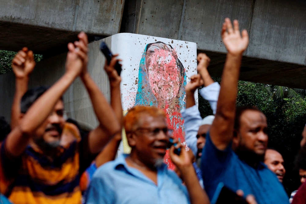 A mural of Prime Minister Sheikh Hasina is seen vandalised by protesters as people celebrate her resignation in Dhaka August 5, 2024. — Reuters pic