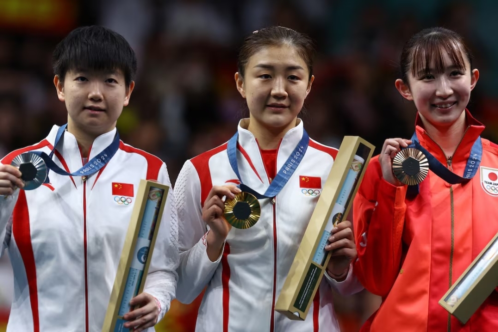 (From left) Silver medallist Sun Yingsha Sun of China, gold medallist Chen Meng of China and bronze medallist Hina Hayata of Japan celebrate on the podium during the women’s singles victory ceremony at the Paris 2024 Olympics August 3, 2024. — Reuters pic