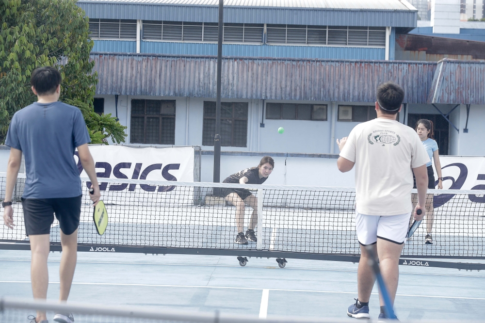 The charm of pickleball lies in its simplicity; setting up a court is relatively easy with just a portable net, paddles, a wiffle ball and a friend. — Picture by Sayuti Zainudin 