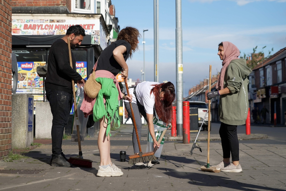 Middlesbrough residents in the UK clear debris from the streets on August 5, 2024, following rioting and looting in England’s worst rioting in 13 years. — AFP pic