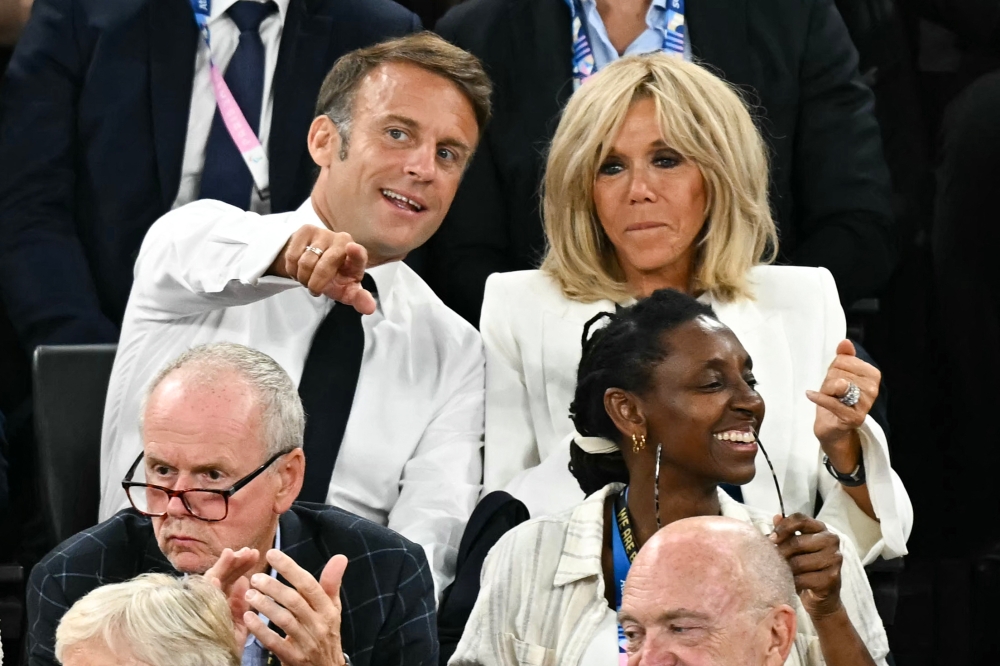French President Emmanuel Macron (left) and his wife Brigitte Macron (right) attend the men's Gold Medal basketball match between France and USA during the Paris 2024 Olympic Games at the Bercy  Arena in Paris on August 10, 2024. — AFP pic