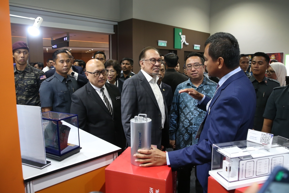Prime Minister Datuk Seri Anwar Ibrahim visits an exhibition booth during the Malaysia Commercialisation Year Summit at Kuala Lumpur Convention Centre, August 12, 2024. With him is Science, Technology, and Innovation Minister Chang Lih Kang. — Picture by Yusof Mat Isa