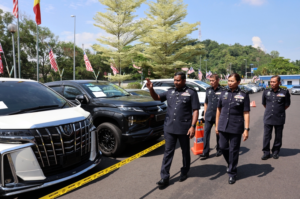 Selangor police chief Datuk Hussein Omar Khan showing the luxury cars seized from the suspects. — Bernama pic
