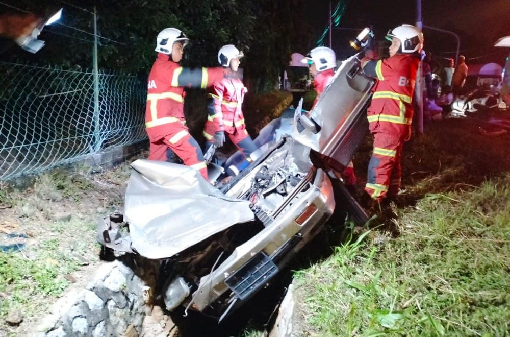 Fire Department personnel at the scene of the accident in Port Dickson early this morning. — Picture from Facebook/PD police 