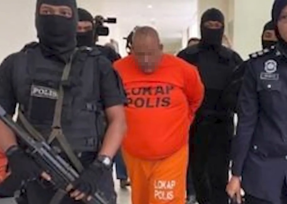 The suspect being taken to the Muar Court Complex, August 14, 2024. — Screengrab from social media  