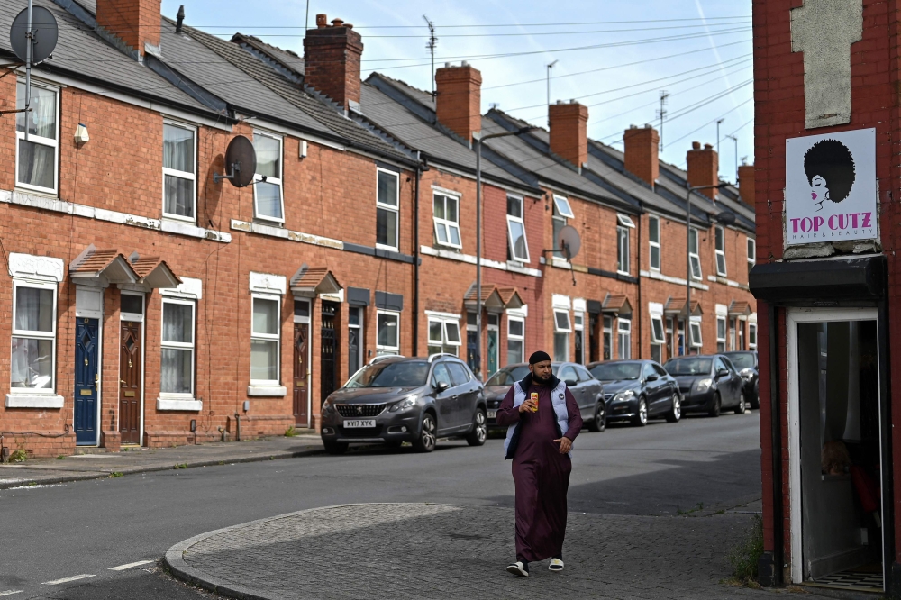 A person walks along on the footpath by a row of houses in the Eastwood area of Rotherham August 13, 2024. — AFP pic
