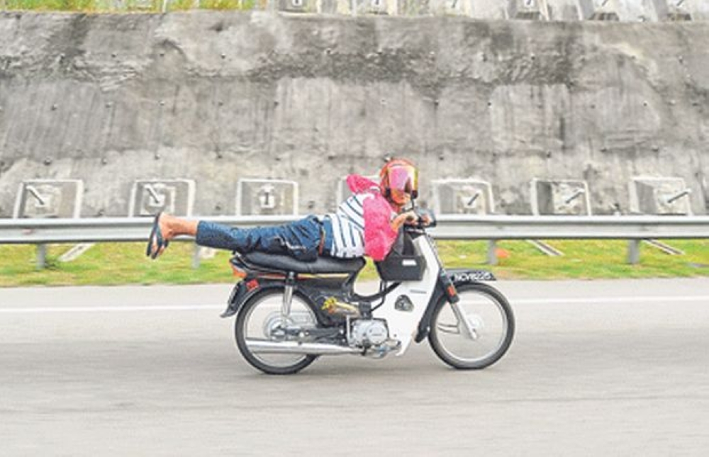 An undated file photograph shows a motorcycle rider performing a stunt on a public road. — Picture by Zuraneeza Zulkifli