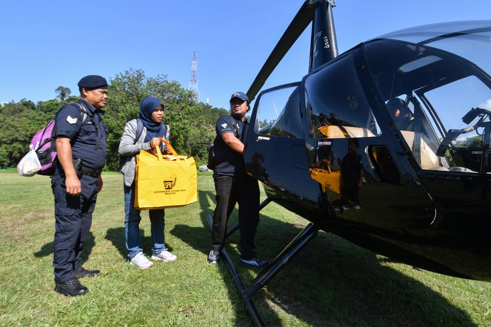 Election officer Wan Nazaliza Wan Ismail (second from left) transports ballot boxes to Pos Gob and Pos Simpor by helicopter during an inspection at Padang Dewan Perdana, Kompleks Perdana, Gua Musang district council, in preparation for the N43 Nenggiri State Legislative Assembly (DUN) by-election, which will take place tomorrow. — Bernama pic