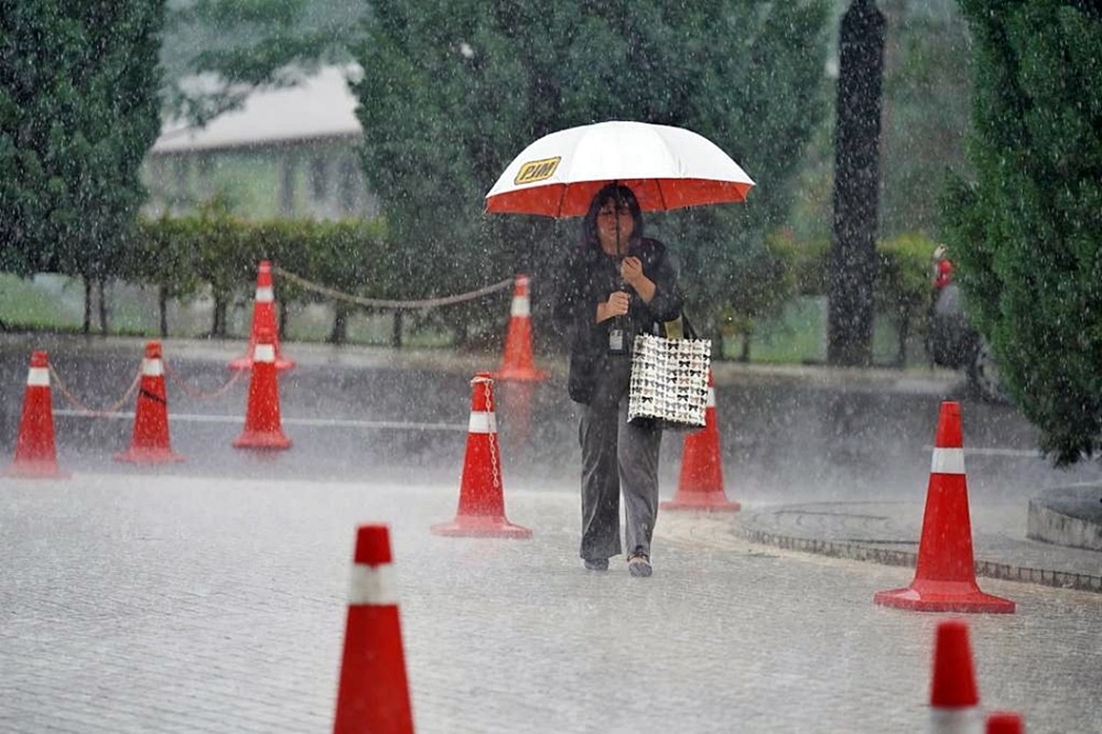 A woman braving the heavy rain in Kuching. — Chimon Upon/The Borneo Post pic 