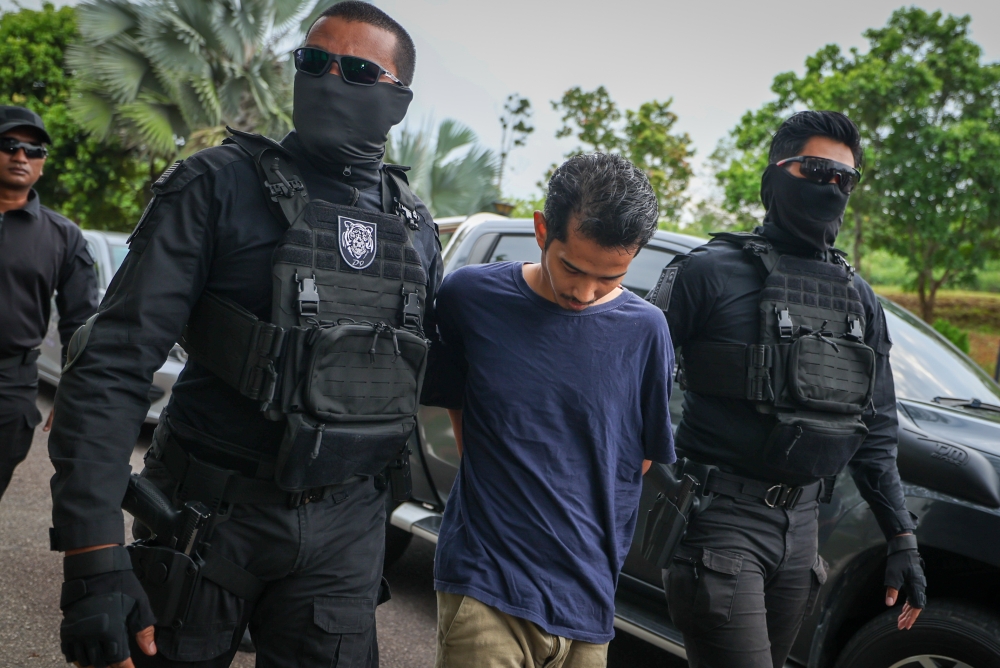 Police escorting murder suspect Fadzly Ariffadzilah to the Magistrate’s Court in Alor Gajah, Melaka for the charging of teacher Istiqomah Ahmad Rozi’s death. — Bernama pic