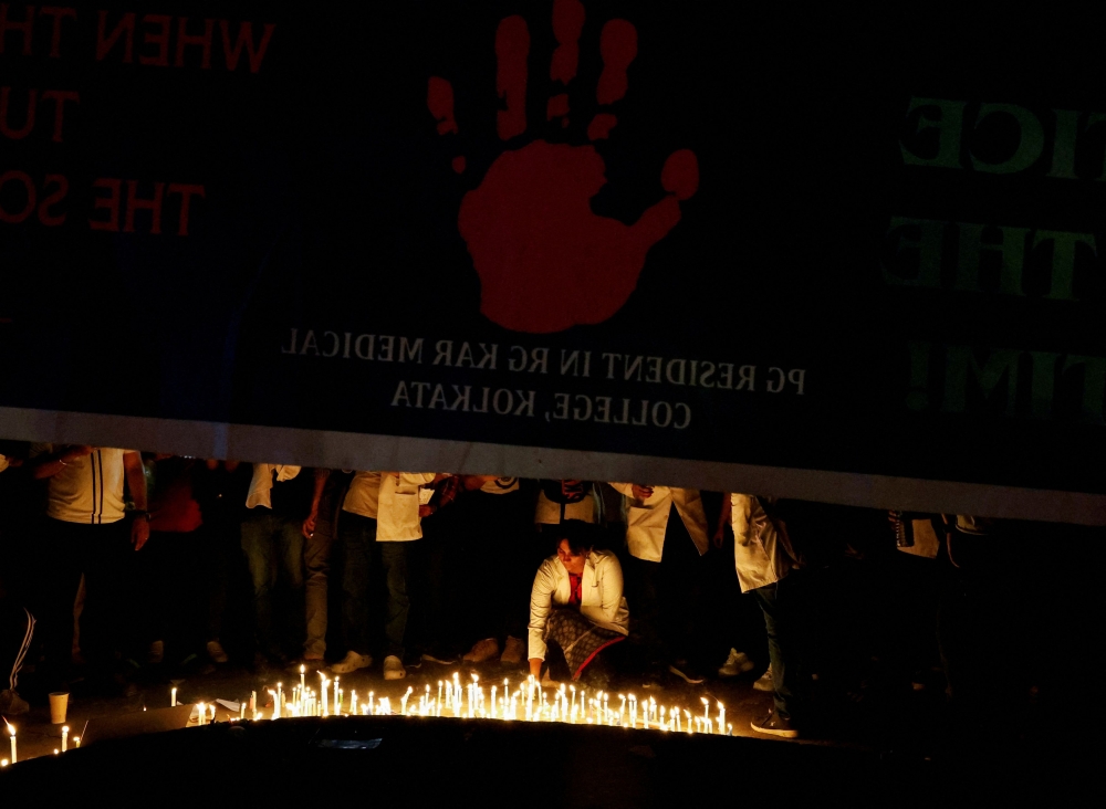 A doctor lights a candle to pay homage to a victim of rape and murder, who was a trainee medic at a hospital in Kolkata, in New Delhi. — Reuters