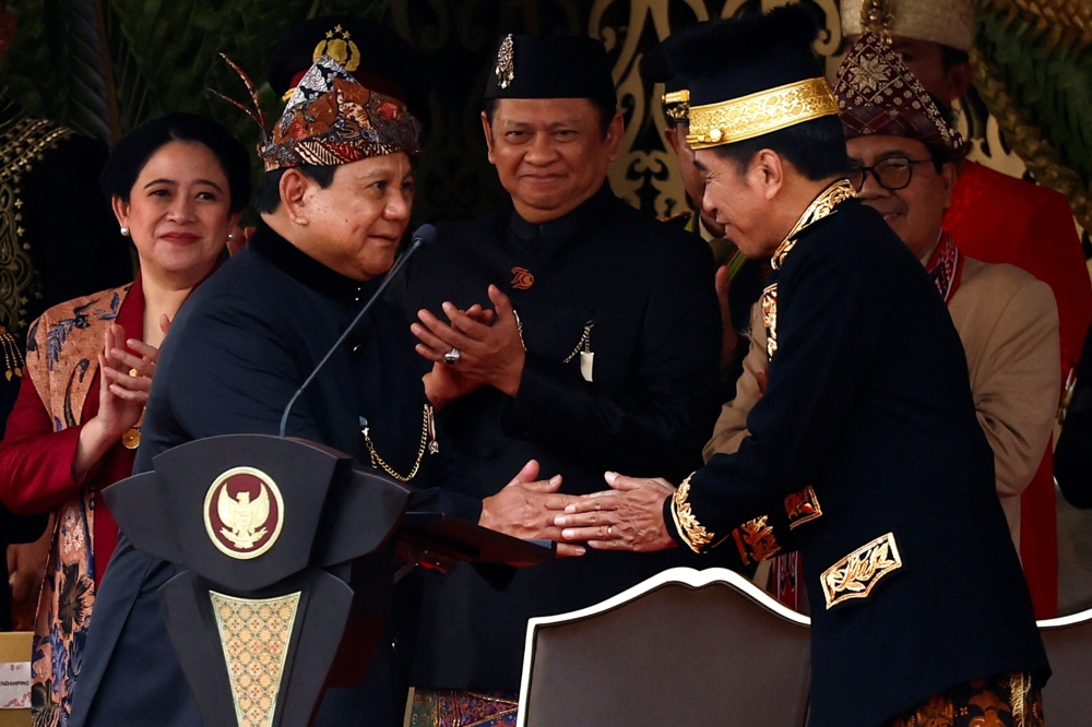 Indonesian President Joko Widodo shakes hands with Defence Minister and President-elect Prabowo Subianto during a ceremony marking the country's 79th Independence Day at the Presidential Palace in the new capital city of Nusantara, East Kalimantan province, Indonesia, August 17, 2024. — Reuters pic