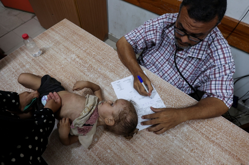 A Palestinian girl is examined by a doctor amid fears over the spread of polio after the first case was reported by the Ministry of Health, as the conflict between Israel and Hamas continues, at Al-Aqsa Martyrs Hospital, in Deir Al-Balah in the central Gaza Strip, August 18, 2024. — Reuters pic