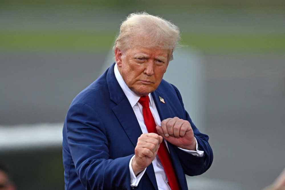 Former US President and Republican presidential candidate Donald Trump gestures during a campaign rally at the North Carolina Aviation Museum & Hall of Fame in Asheboro, North Carolina, August 21, 2024. — AFP pic