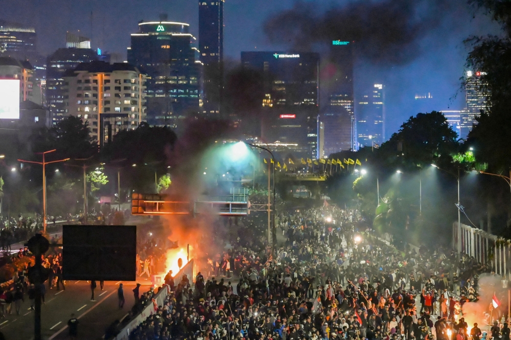 Demonstrators burn objects amid clashes outside the Parliament building in Jakarta on August 22, 2024 during a protest against a move to reverse the Constitutional Court's decision altering eligibility rules for candidates in a key election later this year. — AFP pic