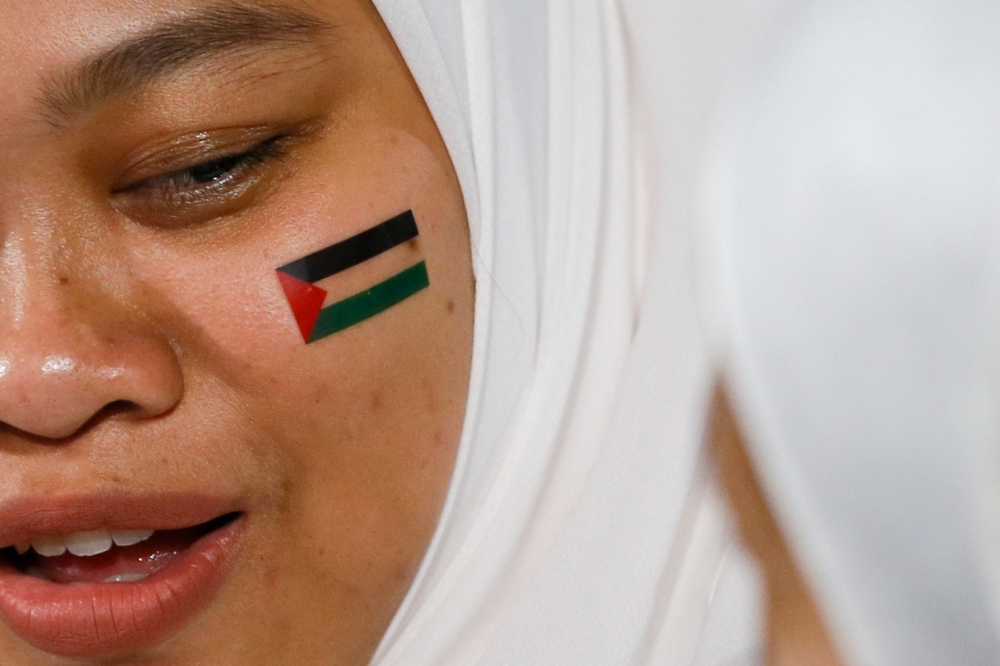 A Malaysian supporter shows off the Palestine flag painted on her cheek during a solidarity rally at the Axiata Arena, Bukit Jalil in Kuala Lumpur. — Picture by Hari Anggara.