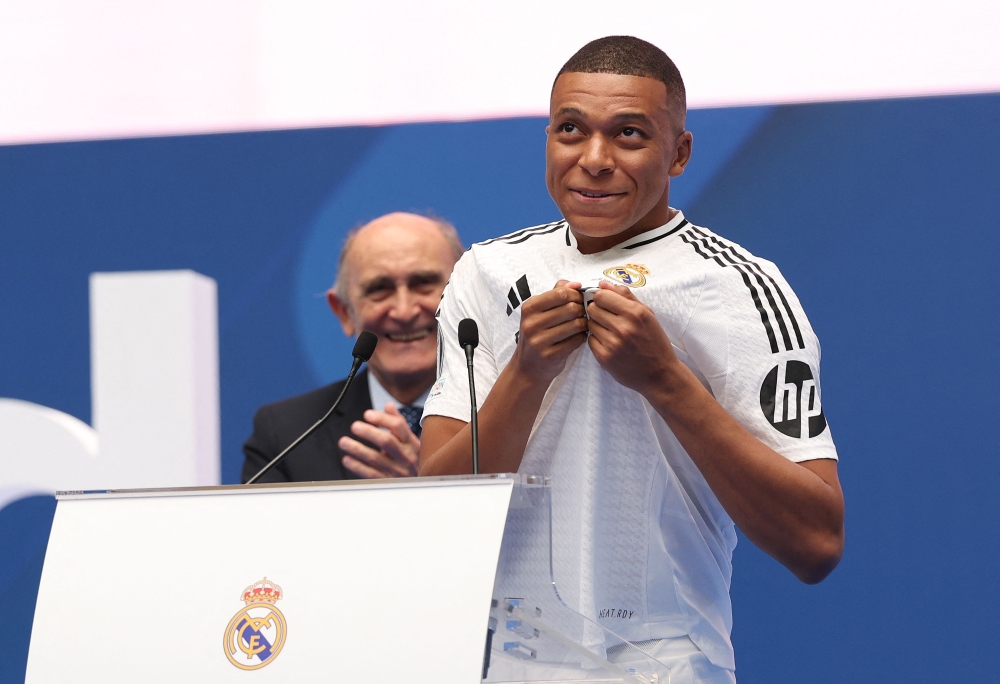 French forward Kylian Mbappe greets fans next to the Honorary President of the Real Madrid Jose Martinez Pirri during his first appearance as a Real Madrid player at the Santiago Bernabeu Stadium in Madrid last month — AFP pic