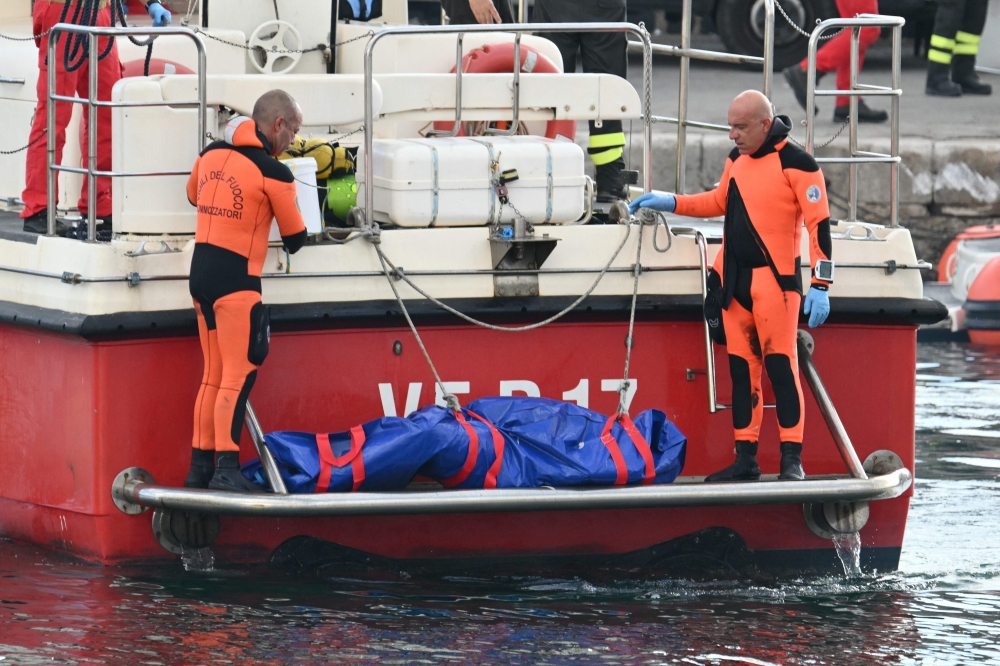 Divers of the Vigili del Fuoco, the Italian Corps of Firefighters arrive in Porticello harbor near Palermo, with a body bag at the back of the boat on August 22, 2024. — AFP pc