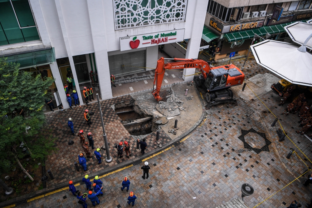 Members of the Malaysian Fire and Rescue Department and the Malaysian Civil Defense Force work to rescue the victim who is a tourist who has fallen into a sinkhole at Jalan Masjid India in Kuala Lumpur August 23, 2024. — Bernama pic