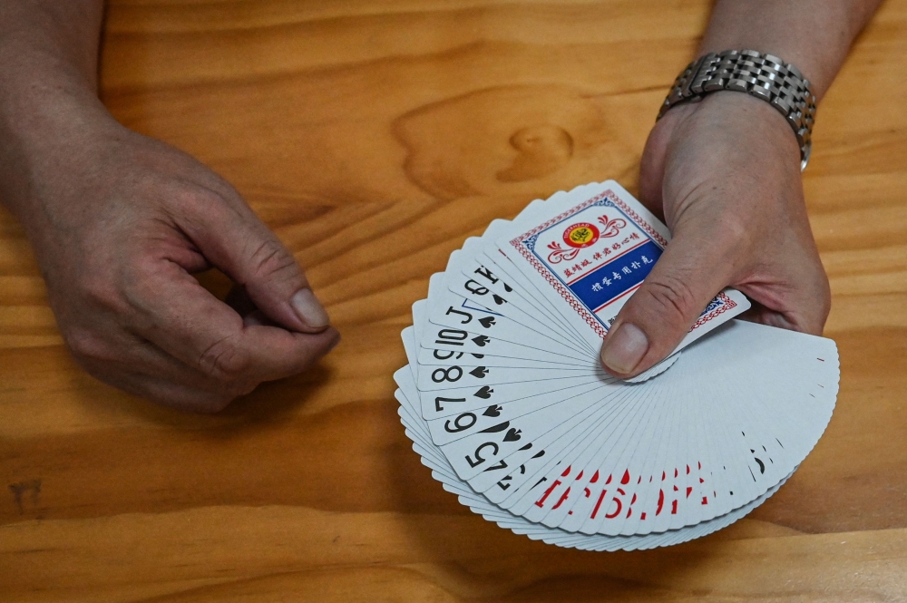 This photo taken on August 14, 2024 shows a sales manager showing playing cards for Guandan or ‘throwing eggs’ at a factory in Wuyi, in eastern Zhejiang province. — AFP pic