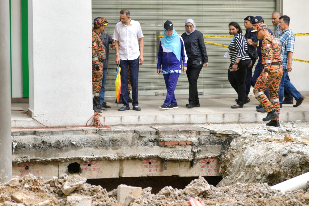 Minister in the Prime Minister’s Department (Federal Territories) Dr Zaliha Mustafa (centre) looks at the area where an Indian tourist fell into a sinkhole along Jalan Masjid India in Kuala Lumpur August 24, 2024. — Bernama pic