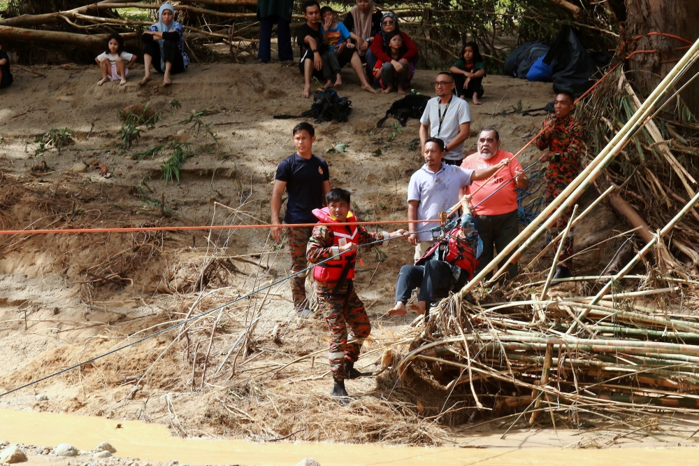 Fire and Rescue Department and Civil Defence Force personnel are seen during a rescue operation at Risda Eco Park Resort after a water surge incident in Tanjung Malim August 24, 2024. — Bernama pic