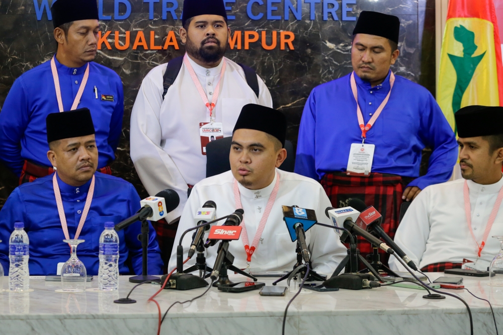 Umno Youth chief Dr Akmal Saleh (centre) speaks to the press at the end of the Umno general assembly in Kuala Lumpur on August 24, 2024. — Picture by Raymond Manuel