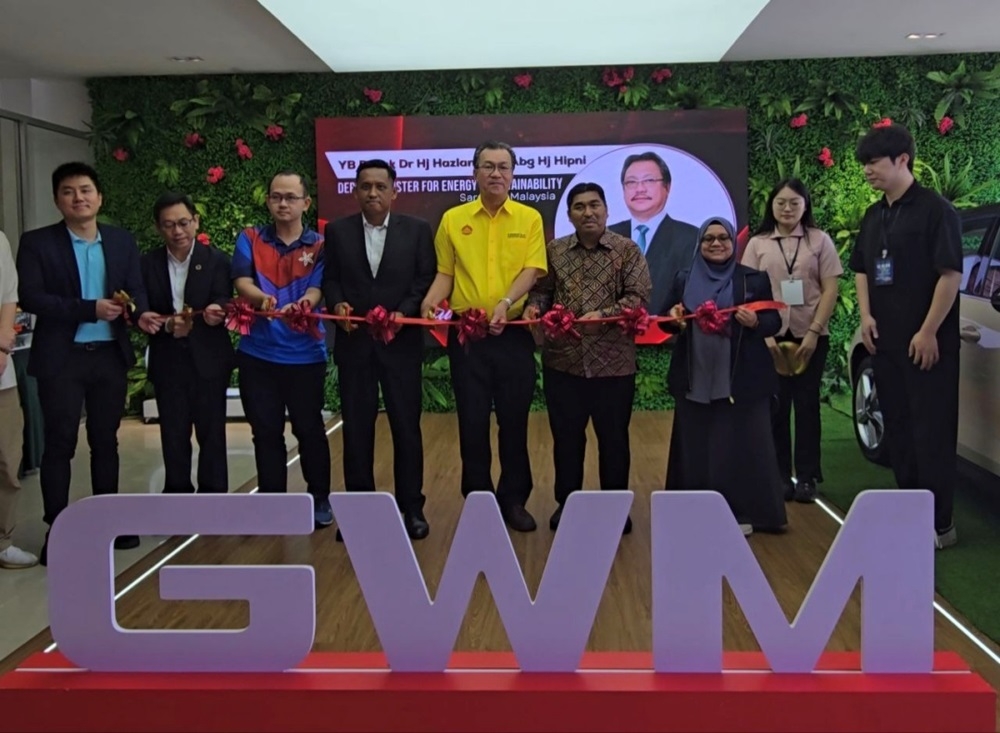 Kota Sentosa assemblyman Wilfred Yap (centre) leads other guests in a ribbon-cutting ceremony to symbolically officiate the ‘EV ‘Car’nival Day’ held at GWM Yuleehong showroom in Kuching. — The Borneo Post pic 
