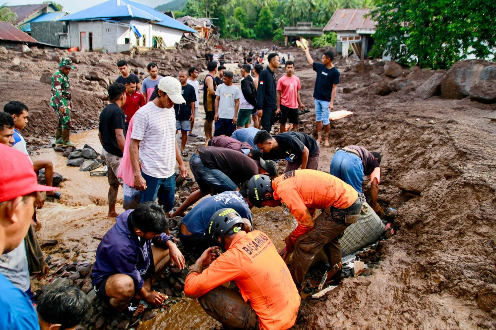 Rescue teams and residents search for victims buried in mud after a flash flood hit the Indonesian village of Rua located at the foot of Mount Gamalama, in Ternate, North Maluku on August 25, 2024. — AFP pic