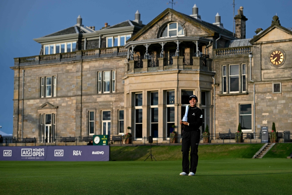 Lydia Ko poses infront of the clubhouse with her trophy after winning the 2024 Women's British Open Golf Championship. — AFP