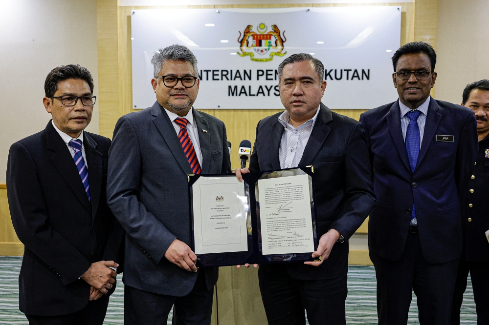 Transport Minister Anthony Loke (second from right) delivers Loke periodic motor vehicle inspection service licence to Puspakom chief executive Mahmood Razak Bahman (second from left). — Bernama pic