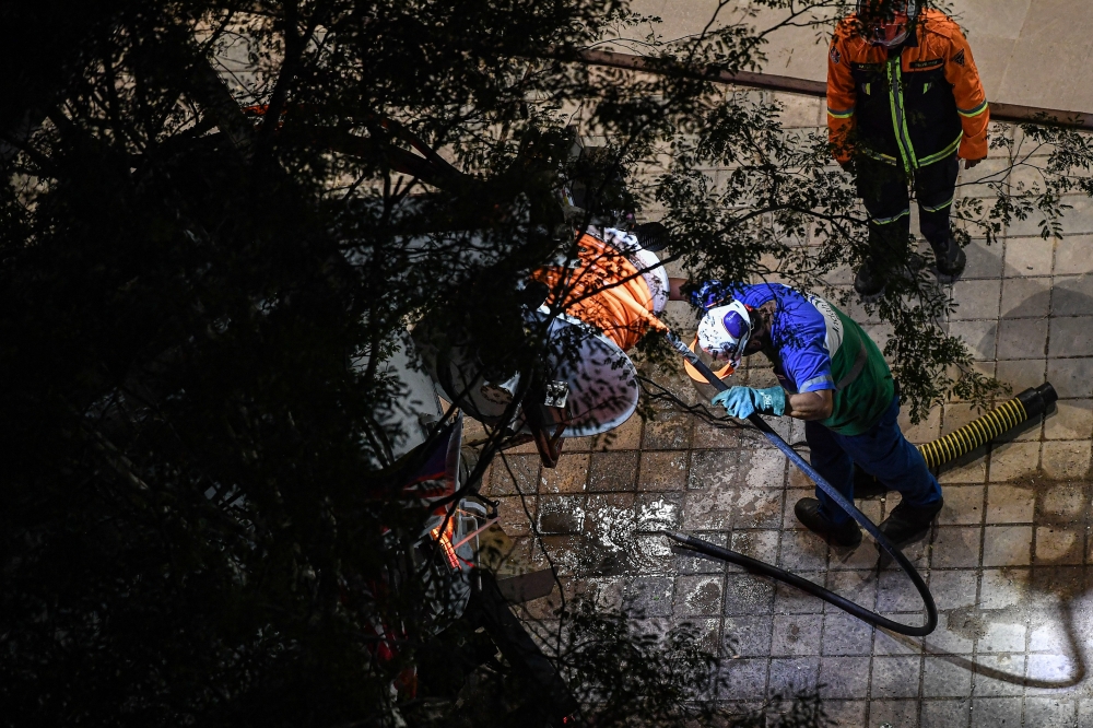 Indah Water personnel and members of the Fire and Rescue team are seen at the site of the recent sinkhole on Jalan Masjid India. — Bernama pic