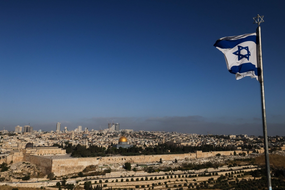 File picture of an Israeli flag flies on the Mount of Olives overlooking the Al Aqsa mosque compound and the city skyline in Jerusalem on April 19, 2024. Saudi Arabia on Tuesday denounced comments made by Israel’s far-right National Security Minister, Itamar Ben-Gvir, who suggested constructing a synagogue within the Al-Aqsa Mosque compound, reported Xinhua. — AFP pic