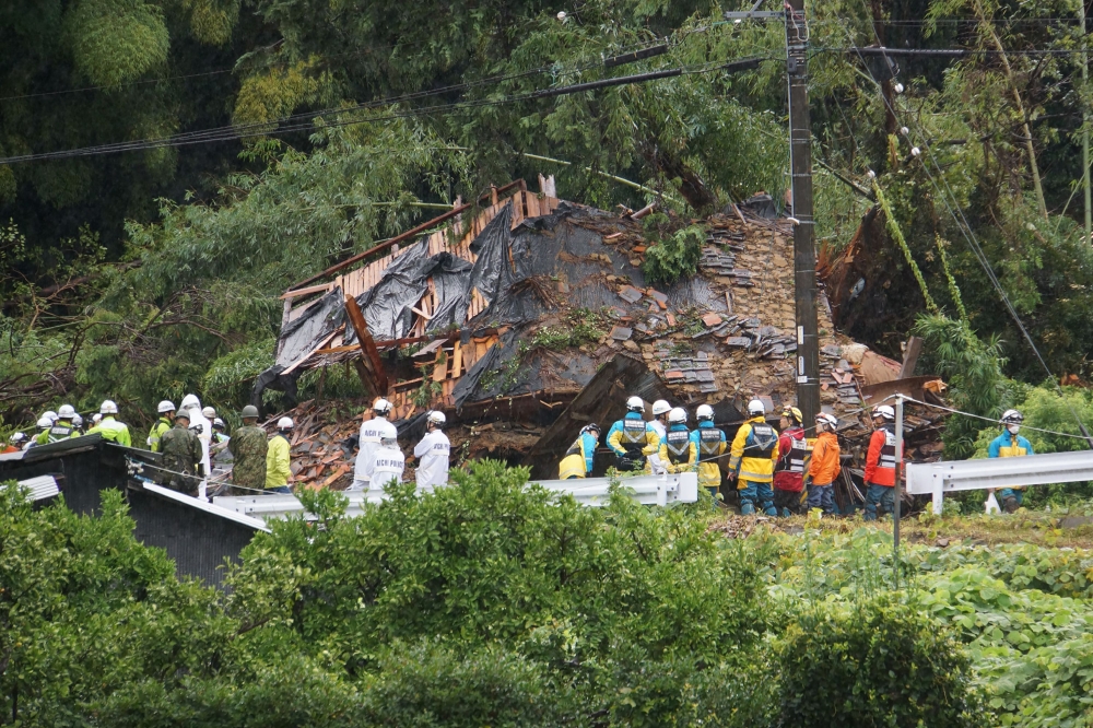 This photo shows rescue workers outside a house that was hit by a landslide in Gamagori, Aichi prefecture on August 28, 2024. — JIJI Press handout pic via AFP