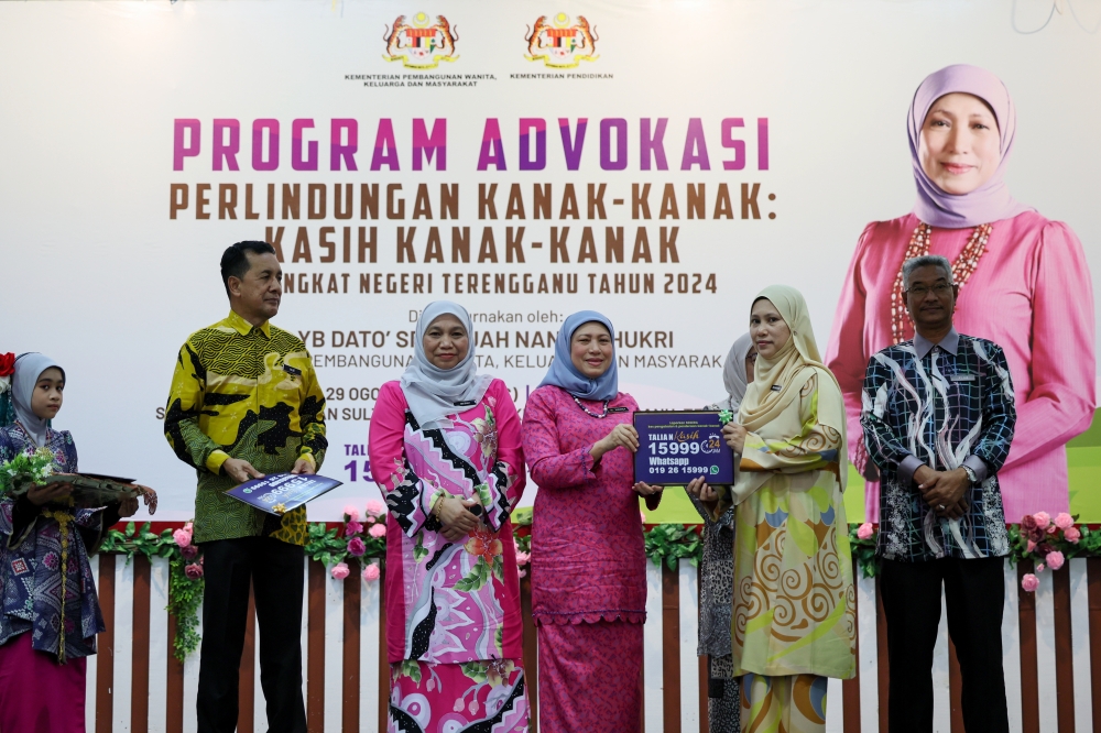 Women, Family and Community Development Minister Datuk Seri Nancy Shukri (centre) presents Talian Kasih 15999 stickers to 30 representatives of Terengganu schools at the Terengganu-level Children Protection Advocacy Programme: Kasih Kanak-Kanak at Sekolah Kebangsaan Sultan Sulaiman II in Kuala Terengganu August 29, 2024. — Bernama pic