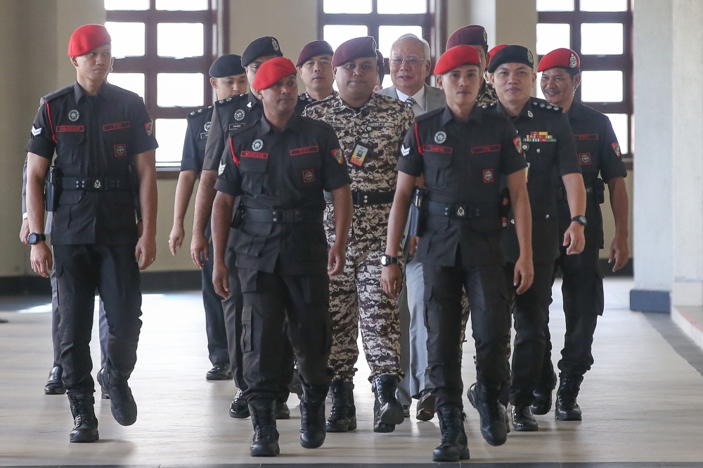 Former prime minister Datuk Seri Najib Razak (in suit) is escorted to one of his trials over the 1MDB scandal, at the Kuala Lumpur Court Complex on August 15, 2024. — Picture by Yusof Mat Isa