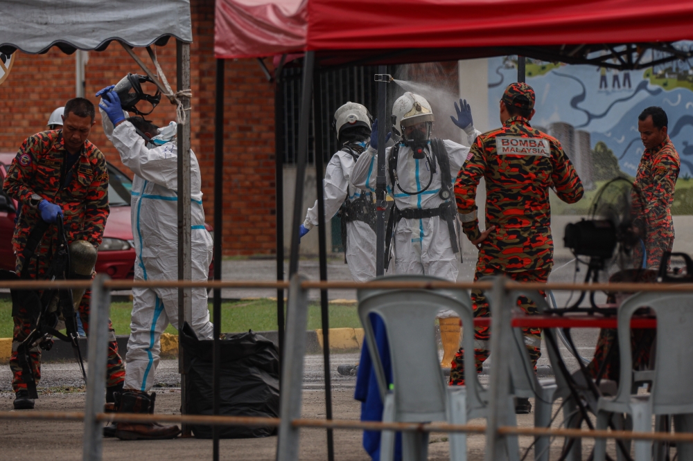 Members of the Malaysian Fire and Rescue Department undergo sanitisation after the search and rescue (SAR) operation for the missing victim in the sinkhole incident at the Indah Water Konsortium (IWK) Pantai Dalam plant, August 30, 2024. — Bernama pic  