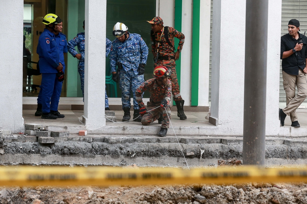 A file photograph shows rescue personnel at the perimeter of the sinkhole along Jalan Masjid India, in Kuala Lumpur. — Picture by Sayuti Zainudin